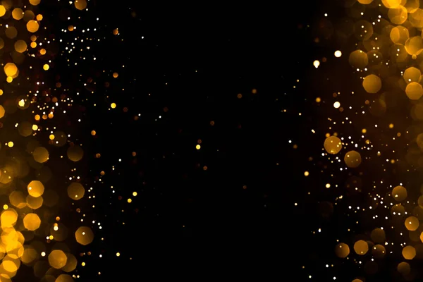 Siyah arka planda altın soyut bokeh. Tatil kavramı