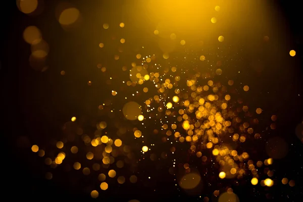Siyah arka planda altın soyut bokeh. Tatil kavramı