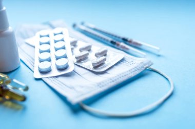 Tabletler, mavi arka planda ilaç şişeleri olan bir paket ilaç..