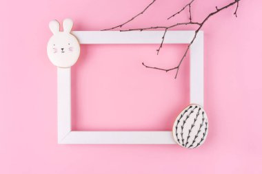 Pembe arka planda Paskalya yumurtası ve tavşan kurabiyesi..