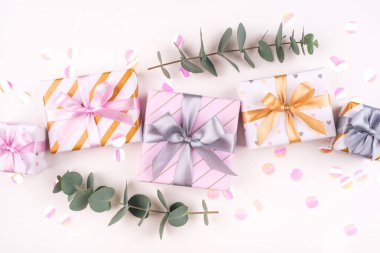 Beyaz arka planda fiyonklu ve konfetili hediye kutuları..