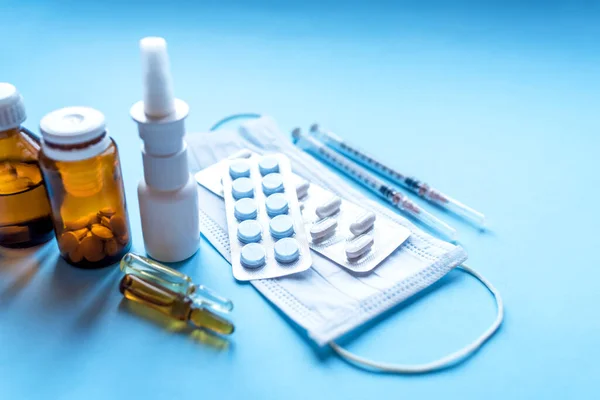 Comprimidos, embalagem de medicamentos com frascos de medicamentos sobre fundo azul . — Fotografia de Stock