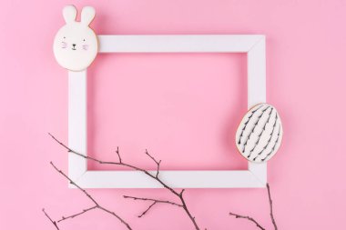 Pembe arka planda Paskalya yumurtası ve tavşan kurabiyesi..