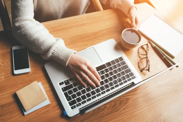 Mujer joven que trabaja en una oficina en casa en su computadora portátil . — Foto de Stock