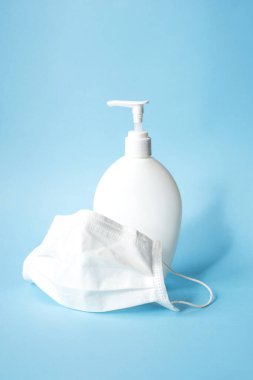 El dezenfektanı jeli ve cerrahi maskeli beyaz plastik şişe..