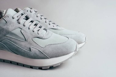 Gri arka planda gri spor ayakkabılar.