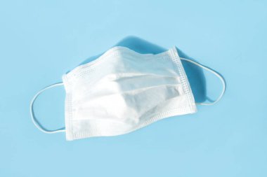 Mavi arka planda tek kullanımlık tıbbi maske.