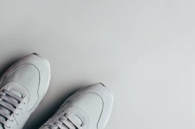 Gri arka planda gri spor ayakkabılar.