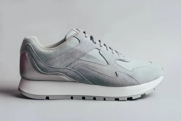 Sneakers grigie su sfondo grigio . — Foto Stock