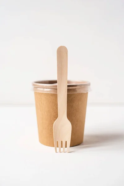 Un recipiente desechable y un tenedor de madera para la entrega de alimentos . —  Fotos de Stock