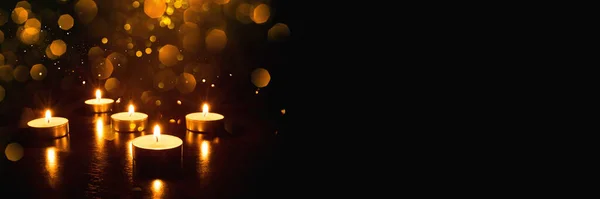 Несколько горящих свечей на черном фоне . — стоковое фото
