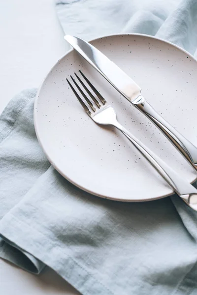 Um prato vazio e talheres em uma mesa branca. — Fotografia de Stock