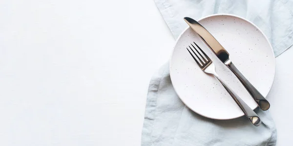 Um prato vazio e talheres em uma mesa branca. — Fotografia de Stock