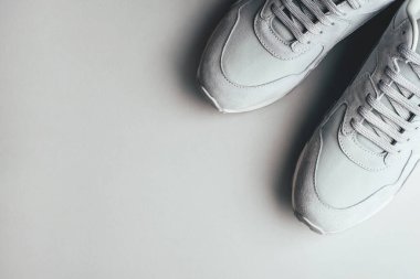 Gri arka planda gri spor ayakkabılar.