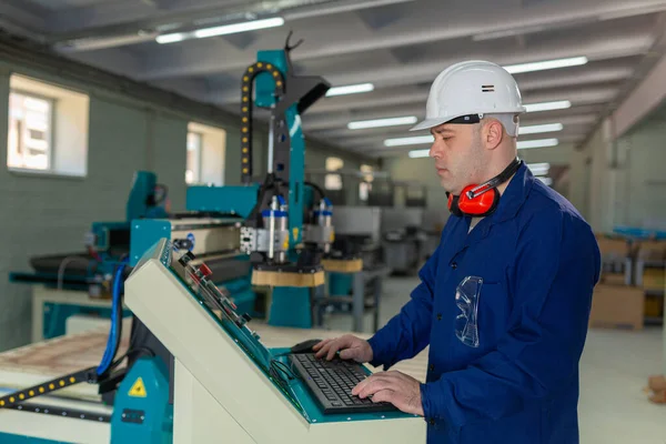 Worker in the Hard Hat Modern Factory CNC machine operator  . Successful, Handsome Man in Modern Industrial Environment.Emotions, Copy Space