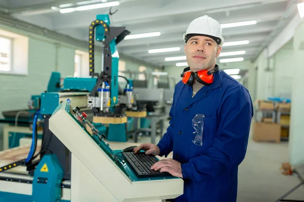 Worker in the Hard Hat Modern Factory CNC machine operator  . Successful, Handsome Man in Modern Industrial Environment.Emotions, Copy Space