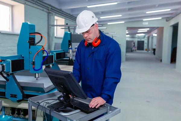 Worker in the Hard Hat Modern Factory CNC machine operator  . Successful, Handsome Man in Modern Industrial Environment.Emotions, Copy Space