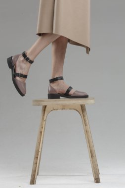 Güzel genç bir kadının ayakkabıları. Sandalyede düz duvara yaslanmış, markasız, kopyalama alanı.