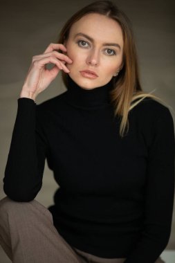 Çizgili pantolon ve siyah bluzlu moda kızı stüdyo arka planında, süpermodel pozu, fotokopi alanı