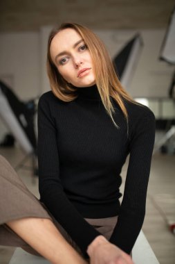 Çizgili pantolon ve siyah bluzlu moda kızı stüdyo arka planında, süpermodel pozu, fotokopi alanı