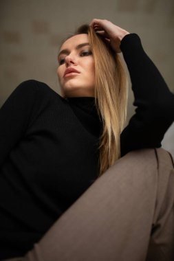 Çizgili pantolon ve siyah bluzlu moda kızı stüdyo arka planında, süpermodel pozu, fotokopi alanı