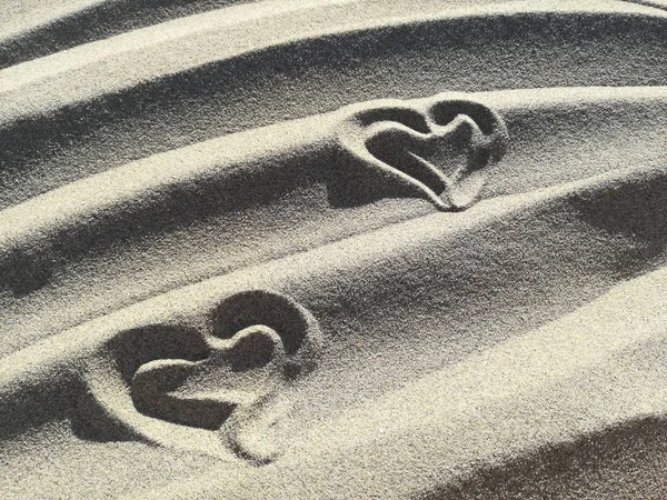 Dos corazones de amor dibujados en la arena de la playa — Foto de Stock