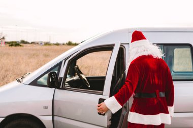 Noel Baba bir minibüse binip teslimatçı olarak çalışıyor.