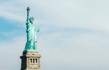 Front view of statue of liberty in New York with blue sky and copy space for text clipart