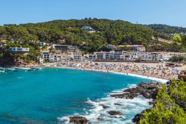 Crowded beach in Costa Brava (Catalonia, Spain). Summer holidays destination in Europe clipart