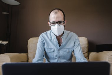 Beyaz maskeli hasta işadamı evden uzakta çalışıyor. Yeni normallik kavramında evden işe gitmek