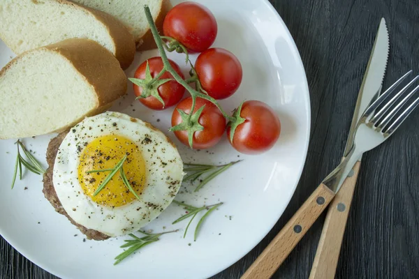 Marha steak sült tojással fűszerekben, fehér tálcán tálalva. Amerikai étel. Sötét fa háttér. Oldalnézetből. Közelkép. — Stock Fotó