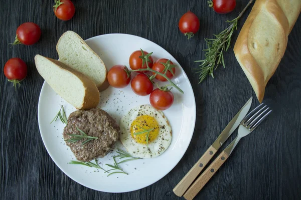 Marha steak sült tojással fűszerekben, fehér tálcán tálalva. Amerikai étel. Sötét fa háttér. Oldalnézetből. Közelkép. — Stock Fotó
