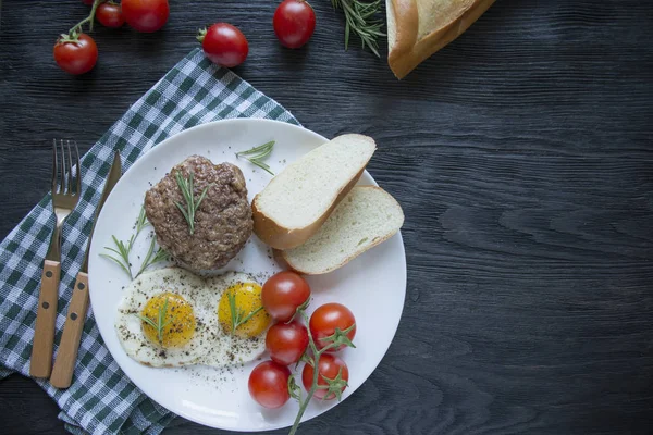 Marha steak sült tojással fűszerekben, fehér tálcán tálalva. Amerikai étel. Sötét fa háttér. Oldalnézetből. Közelkép. A szöveg helye. — Stock Fotó