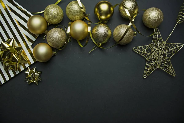 美丽的圣诞节金色银色装饰在黑暗的黑色背景上的小球。平面平面设计。复制空间。水平. — 图库照片