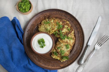 Kabaklı börek. Vejetaryen kabak krepleri taze otlar ve ekşi kremayla servis ediliyor. Hafif arkaplan.