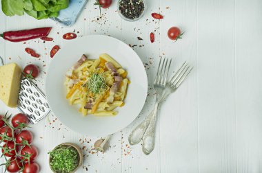 Peynirli İtalyan makarnası, balkabağı ve kızarmış domuz pastırması, beyaz tabakta servis ediliyor. Hafif ahşap zemin. Metin için boşluk.