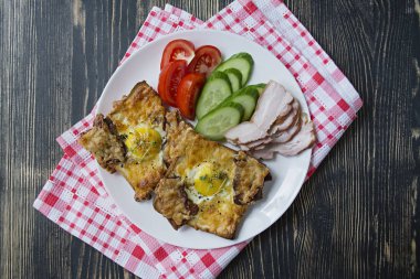 Koyu ahşap arka planda yumurta, sebze ve pastırmalı ızgara sandviç. Nefis bir kahvaltı. Metin için yer.