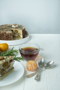 Hafif ahşap arka planda cam bardakta çay. Biberiye ve mandalinalı siyah çay. Metin için boşluk.
