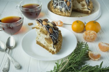 Açık ahşap zemin üzerinde beyaz bir tabakta bademli çikolatalı pasta. Pastalı çay partisi. Yemek masası..