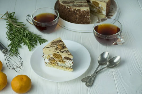 İçinde badem ve haşhaş tohumları olan bir pasta, beyaz bir tabakta krema, açık tahta bir zeminde masanın üzerinde. Pastalı çay partisi. Yemek masası. Metin için boşluk.