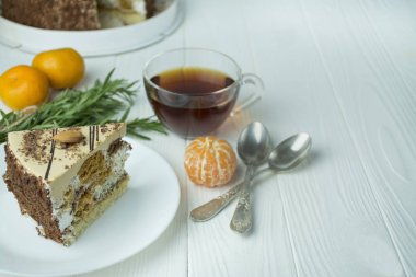 İçinde badem ve haşhaş tohumları olan bir pasta, beyaz bir tabakta krema, açık tahta bir zeminde masanın üzerinde. Pastalı çay partisi. Yemek masası. Metin için boşluk.