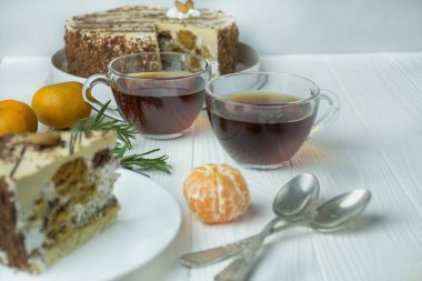 Hafif ahşap arka planda cam bardakta çay. Biberiye ve mandalinalı siyah çay. Metin için boşluk.