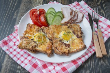 Koyu ahşap arka planda yumurta, sebze ve pastırmalı ızgara sandviç. Nefis bir kahvaltı. Metin için yer.