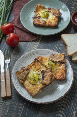 Koyu ahşap arka planda yumurta, sebze ve pastırmalı ızgara sandviç. Nefis bir kahvaltı. Metin için yer.