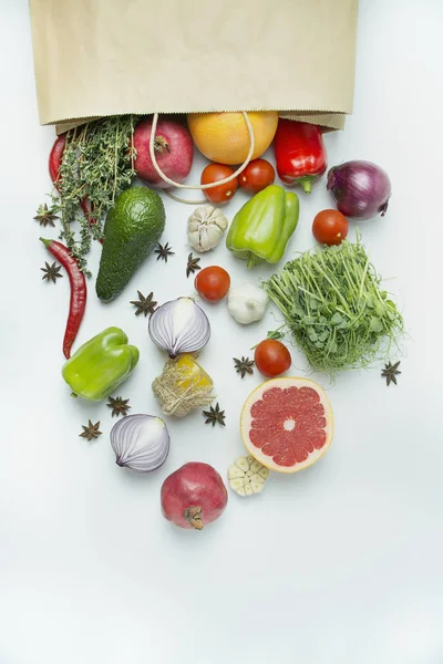 Свежие овощи и ингредиенты в бумажном пакете. Полный пакет свежих овощей и фруктов на белом фоне. Диетическое или вегетарианское питание. Стол фоновое меню. Пространство для текста . — стоковое фото
