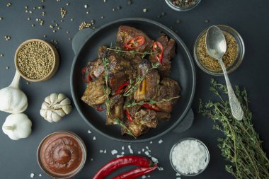 Izgarada pişmiş pirzola. Baharatlı ve taze otlu ızgara domuz pirzolası. Karanlık arka plan. Mesaj için yer var. Tablo arkaplan menüsü.