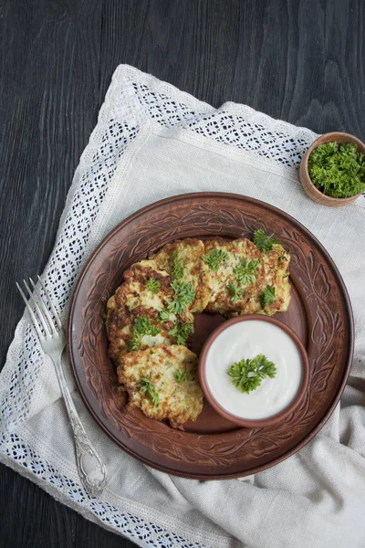 Frittelle di zucchine. Frittelle di zucchine vegetariane con erbe fresche e panna acida. Una pila di pancake. Tavolo da pranzo. Equilibrio cibo sano. Sfondo chiaro . — Foto Stock