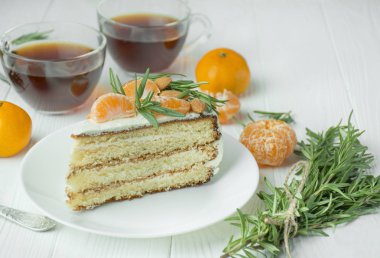 Beyaz bir tabakta mandalinalı kek, açık ahşap bir arka planda masanın üzerinde. Pastalı çay partisi. Yemek masası. Metin için boşluk.