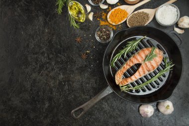 Izgara somon fileto bifteği, aromatik otlar, baharatlar ve sebzeler ızgarada. Deniz ürünleri. Yemek pişirme konsepti. Mutfak geçmişi. Masa arkaplan menüsü. Boşluğu kopyala