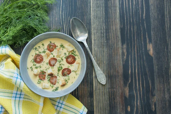 Сырный суп с жареными сосисками и травами. Вкусный сырный суп в белой тарелке. Обеденный стол. Баланс здорового питания. Принято. Деревянный фон . — стоковое фото